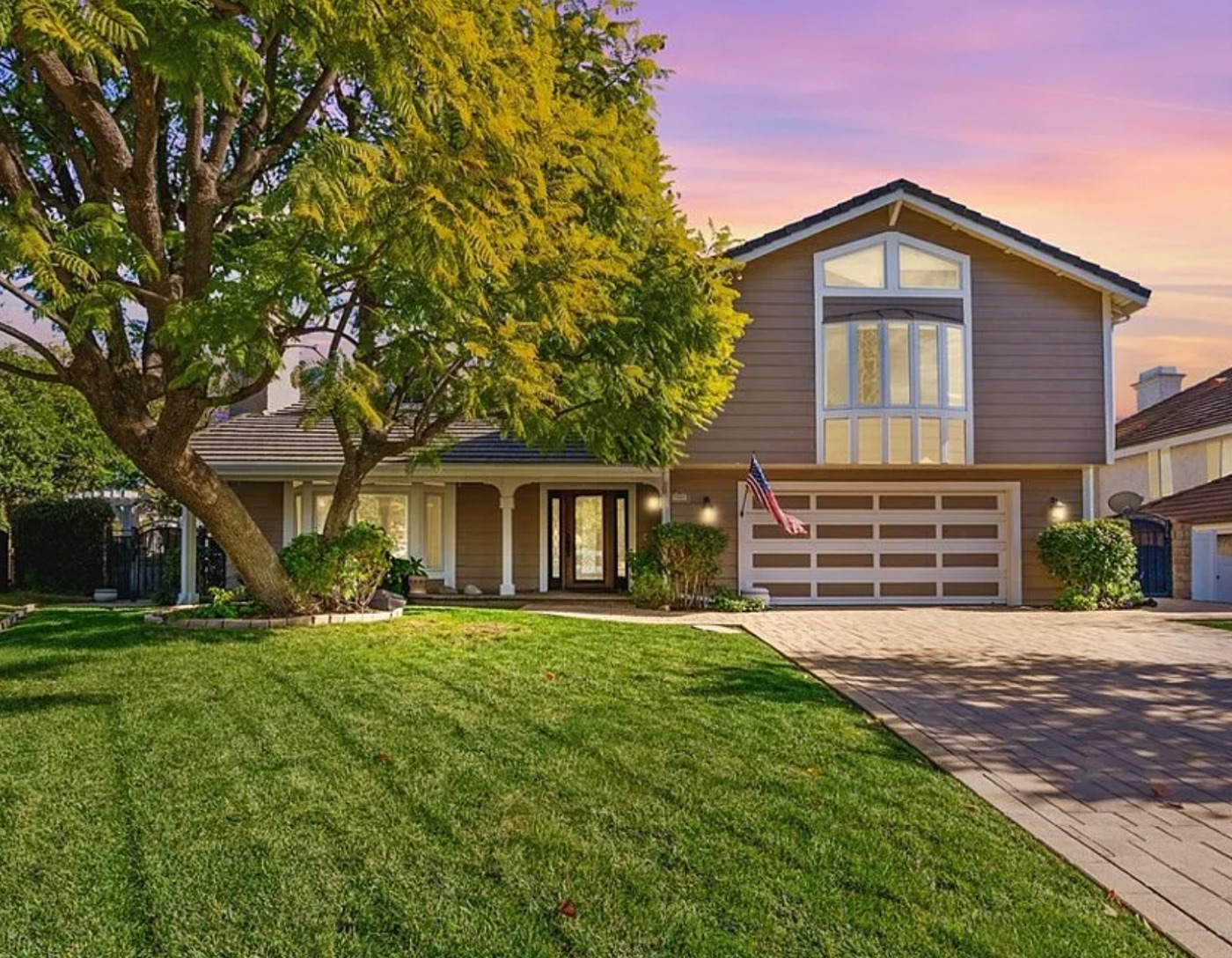 Two-story Ventura County home at dusk with mature trees